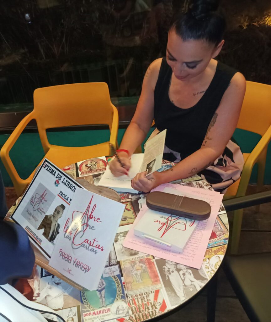 Paola Yenay firmando su novela Abre las Cartas
